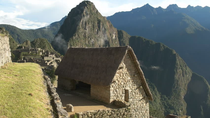 high angle shot of a restored hut at machu picchu on a sunny morning