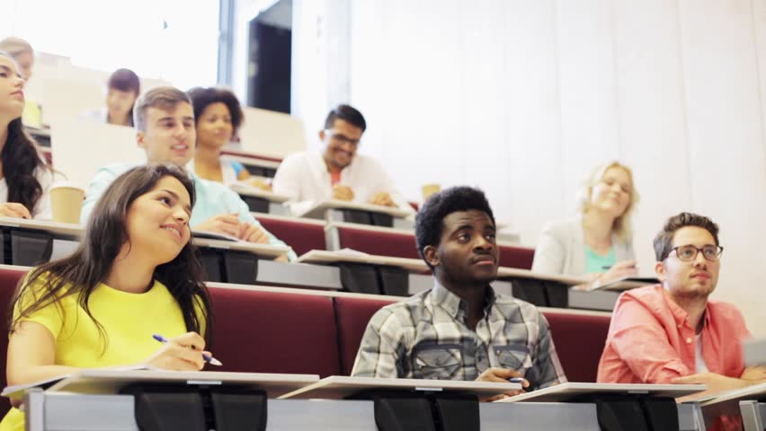 Education, high school, university, learning and people concept - group of international students with notebooks sitting in lecture hall and talking | Shutterstock HD Video #17854123
