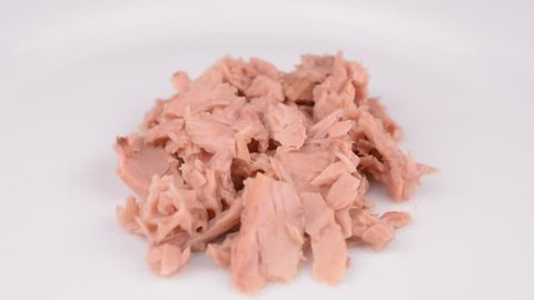 Tuna chunks in brine on white plate rotating
