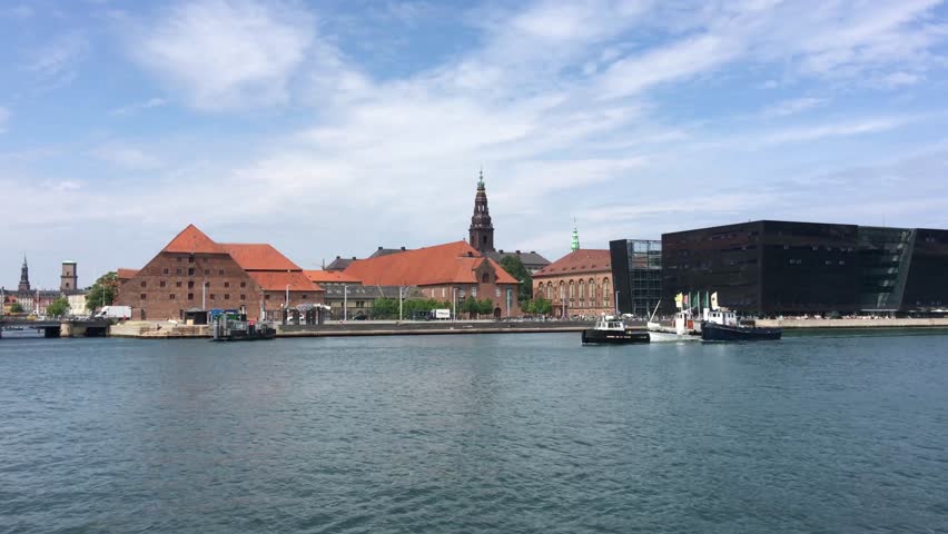 Boats in front of the Kobenhavns Havn with the Royal Library in Copenhagen Denmark