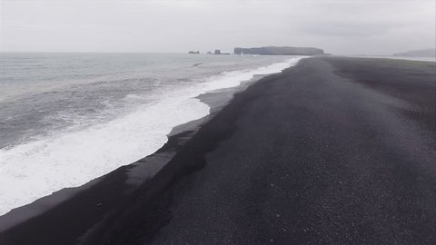 Flyover Coast Viewing Distant Island At Black Sand Beach in Vik Iceland
