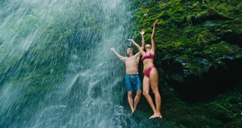 Couple Relaxing Under Waterfall