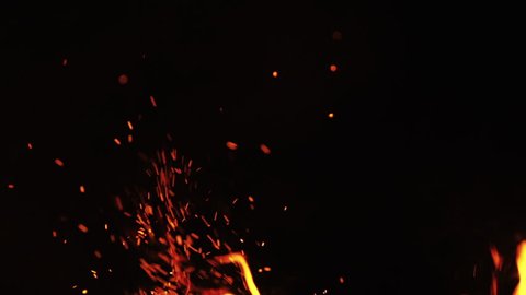 fire flames with sparks from campfire over black background