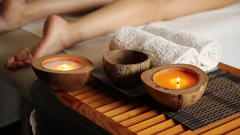 young woman gets a foot massage in the spa salon. close-up of candles