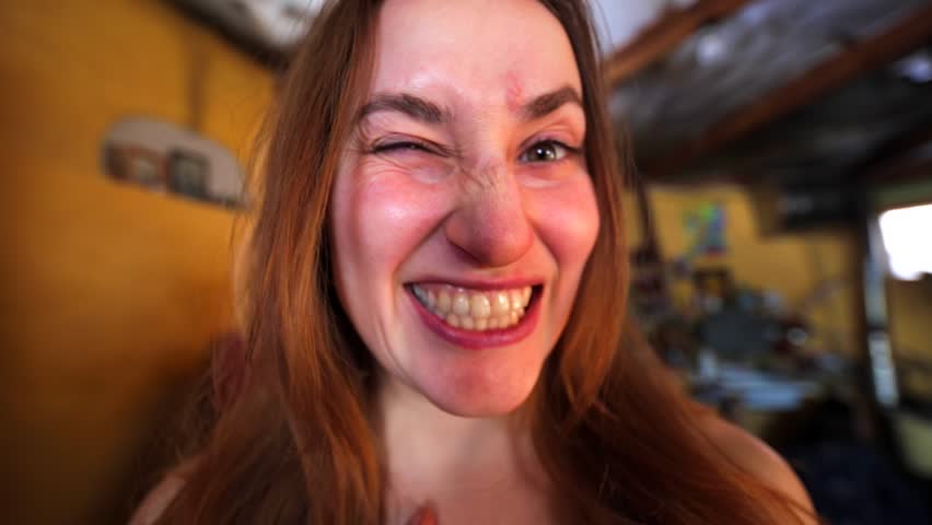 Young long hair woman is making faces into the camera. The Chachzaevka Ecovillage. Altai mountains, Siberia, Russia. From 2011 people here explore alternative energy, green building, natural farming