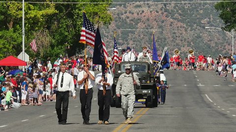 MORONI, UTAH - JULY 4, 2016: Color guard marches with US flag and Utah state flag to mark the start of annual 4th of July parade in a small rural American town as they celebrate America's independence
