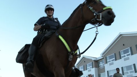 DULUTH, MINNESOTA - CIRCA 2016: Three police officers mounted on horses travel close by as they pass camera.