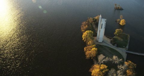 An aerial 4k tracking shot of the Canberra Carillon in the late afternoon. As we track around we get a beautiful flare on the water and Carillon. the Shot on a Red Epic. 
