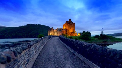Footpath to the beautiful illuminated Eilean Donan Castle at sunset in Scotland
