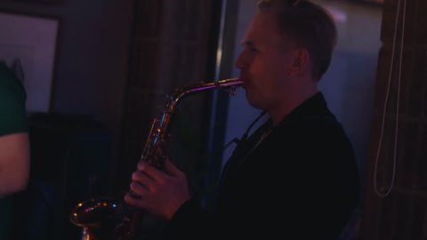 Man play saxophone on party in nightclub. Perform. Holidays. Cheering. Musician Dance
