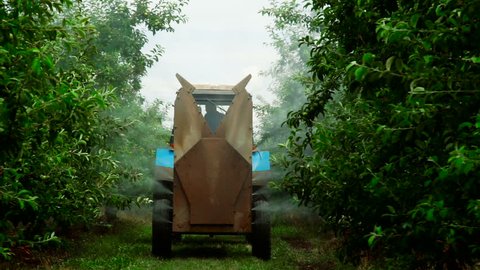 A Rear view of the Fan Sprayer applying Chemicals in an Apple orchard.