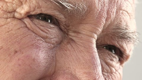 pensive sad old man eyes: close up footage of retired sad old man