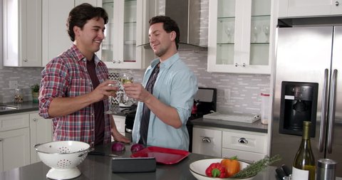 Male gay couple preparing a meal and drinking wine, shot on R3D 