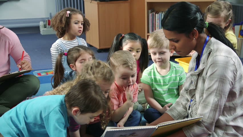 Students interacting with their teacher during story time at nursery. They are sitting on the floor in the classroom. Royalty-Free Stock Footage #17913607