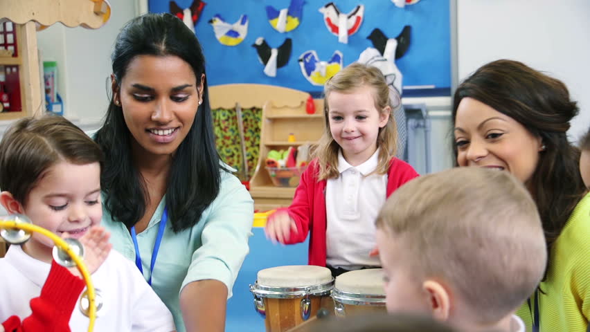 Nursery students enjoying a music lesson in the classroom with their teachers. Royalty-Free Stock Footage #17913616