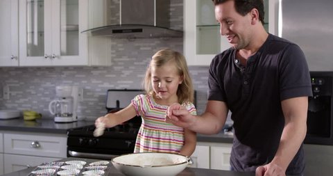 Caucasian girl spooning out cake mix mix for baking with her dad, shot on R3D