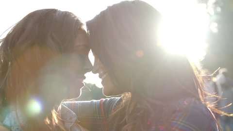 Lesbian couple embrace touching noses, eyes closed, close up Stockvideo
