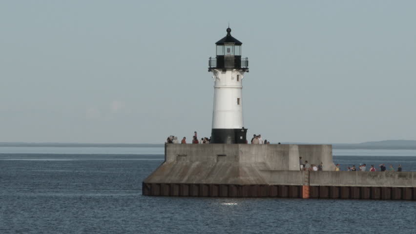 Travelers gather at the end of the pier by harbor lighthouse on Lake Superior in Duluth, Minnesota.