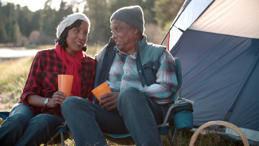 Senior black couple on camping trip outside tent, close up