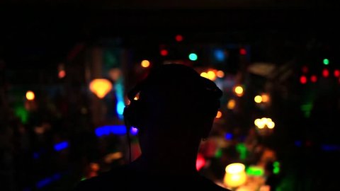 Silhouette of a dj.Making music.In the club.Medium shot.