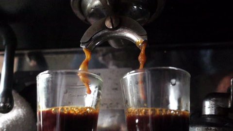 Closeup prepare double shot of espresso coffee, slow motion