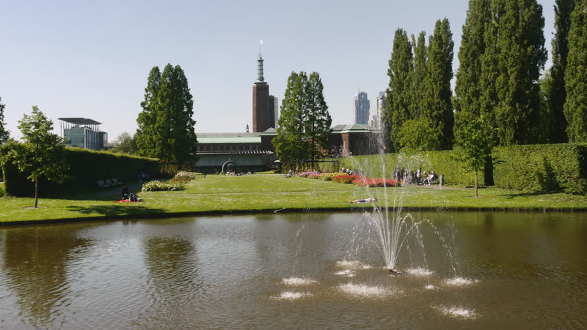 Fountain in sunny museumpark in Rotterdam. The Boijmans van Beuningen museum in the background.
