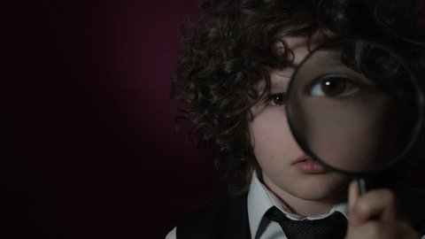 4k Shoot of a Cute Businessman Child Holding a Magnifying Glass on his Eye