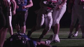 A football player celebrates and jumps into his teammates arms after a touchdown