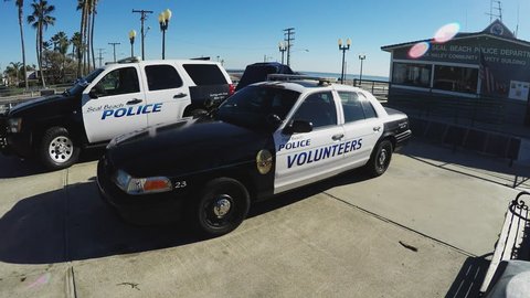 SEAL BEACH, CA/USA: June 6, 2016- Close up shot of Seal Beach California Police Department vehicles. Clip shows the police department building and pier at the beach in the background.