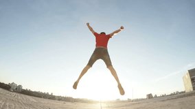 Slow motion Happy Man jumping on the roof at sunset, sunbeams in the lens, wide angle, low shoot point - Powered by Shutterstock - Get 15% off with code: PIKWIZARD15