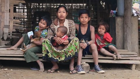 MRAUK-U, MYANMAR - JANUARY 28, 2016: Unidentified poor family sits on the street. Poverty is a major issue in Burma