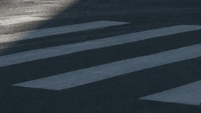 Ungraded: Young man rolls a bike on a zebra crossing on a hot summer day. Feet close-up. 
