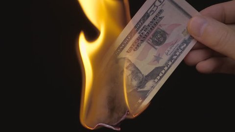 Hand holds 50 dollars on a black background, and burned it. S-log - High Dynamic Range. Slow motion, high speed camera, 250fps