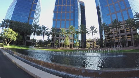 IRVINE CA/USA: May 27, 2016- A beauty shot rolling past a fountain in an Irvine California business park. High rise corporate office buildings loom over a scenic courtyard.