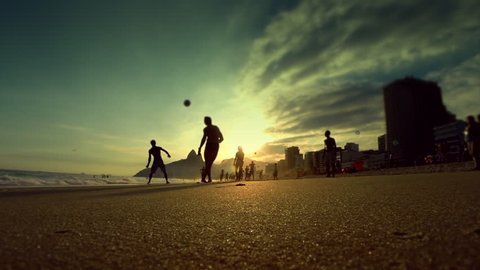 Silhouettes of Brazilians playing beach soccer at sunset on the shore of Ipanema Beach in Rio de Janeiro, Brazil