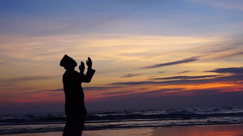 silhouette of man praying in sunset background. Royalty-Free Stock Footage #17984980
