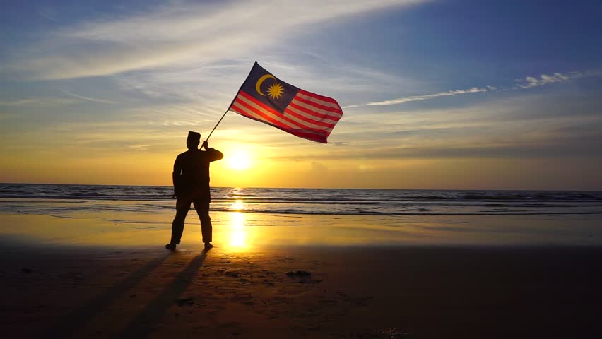 silhouette man with waving malaysia flag at beach on sunset. Independence Day Royalty-Free Stock Footage #17986747