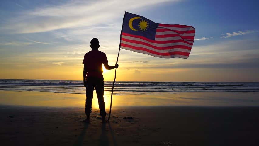 silhouette man with waving malaysia flag at beach on sunset. Independence Day Royalty-Free Stock Footage #17986792