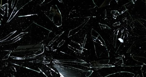Stone breaking Pane of Glass against Black Background, Slow Motion 