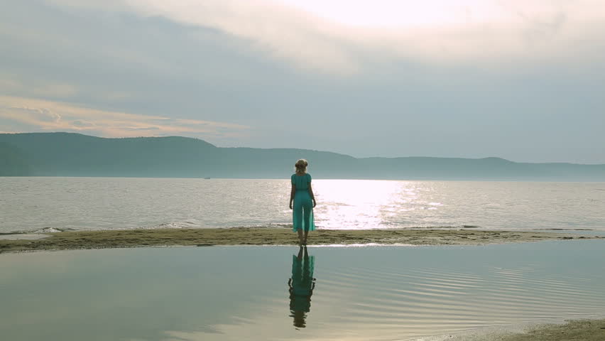 Party and people concept - group of smiling teen girls jumping on beach. Silhouette of three young women running around and jumping on the sandy beach at sunset.