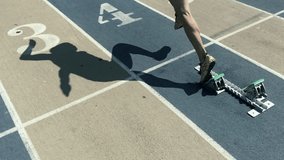 Athlete in gold shoes starting a race in slow motion from the starting blocks on a faded blue and tan running track  - Powered by Shutterstock - Get 15% off with code: PIKWIZARD15