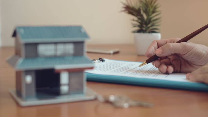 Woman agent signing document and giving key of new house to customer. Lease agreement concept.  Royalty-Free Stock Footage #18014854