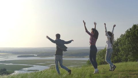 Group Of Friends rejoice on a high hill at sunset