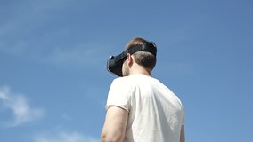 handsome man uses a virtual reality glasses on the backfound of sky - Powered by Shutterstock - Get 15% off with code: PIKWIZARD15