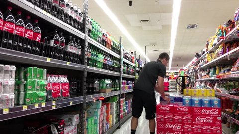 Burnaby, BC, Canada - July 11, 2016 : Grocery clerk stocking drink in Walmart store with 4k resolution