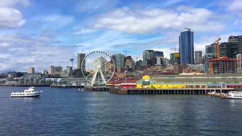 Boat travels toward Seattle skyline and ferris wheel