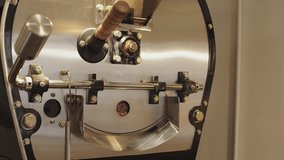 Looped video of front of working professional coffee roasting machine while almost done bake aromatic beans and ready to release