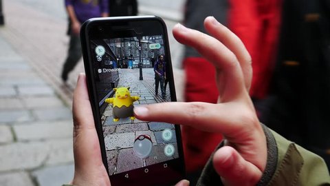 ABERDEEN, UNITED KINGDOM - JULY 15, 2016: People playing "Pokemon GO" the hit augmented reality smart phone app while trying to find Pokemon on July 15, 2016 in Aberdeen, United Kingdom.
