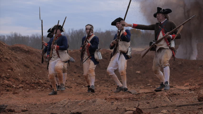 VIRGINIA - OCTOBER 2014 - Reenactment, large-scale, epic American Revolutionary War anniversary recreation -- middle of battle.  Continental Soldiers fire muskets and attack earthworks, explosions.