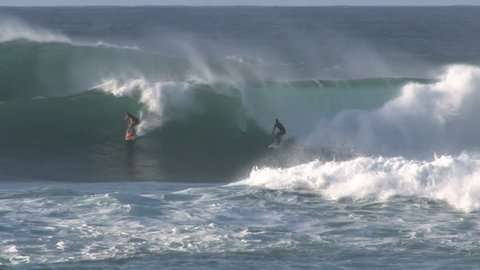 Surfers on large waves on north shore. Famous for big waves and surf competitions in Oahu, Hawaii